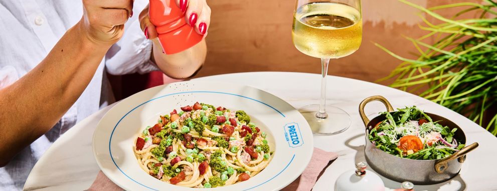 Someone eating pasta and a salad at Prezzo