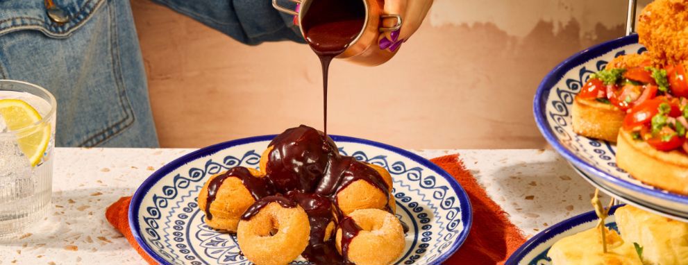 Pouring chocolate over doughnuts